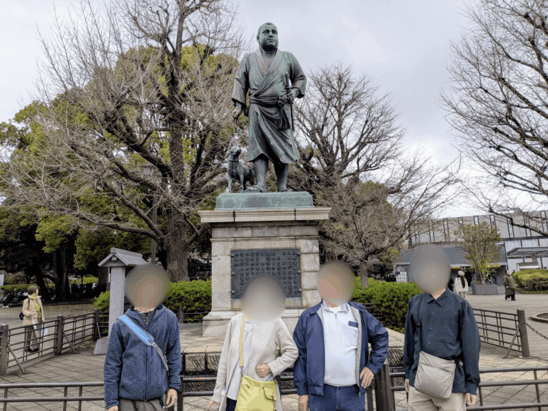 西郷隆盛像の前で記念撮影する家族